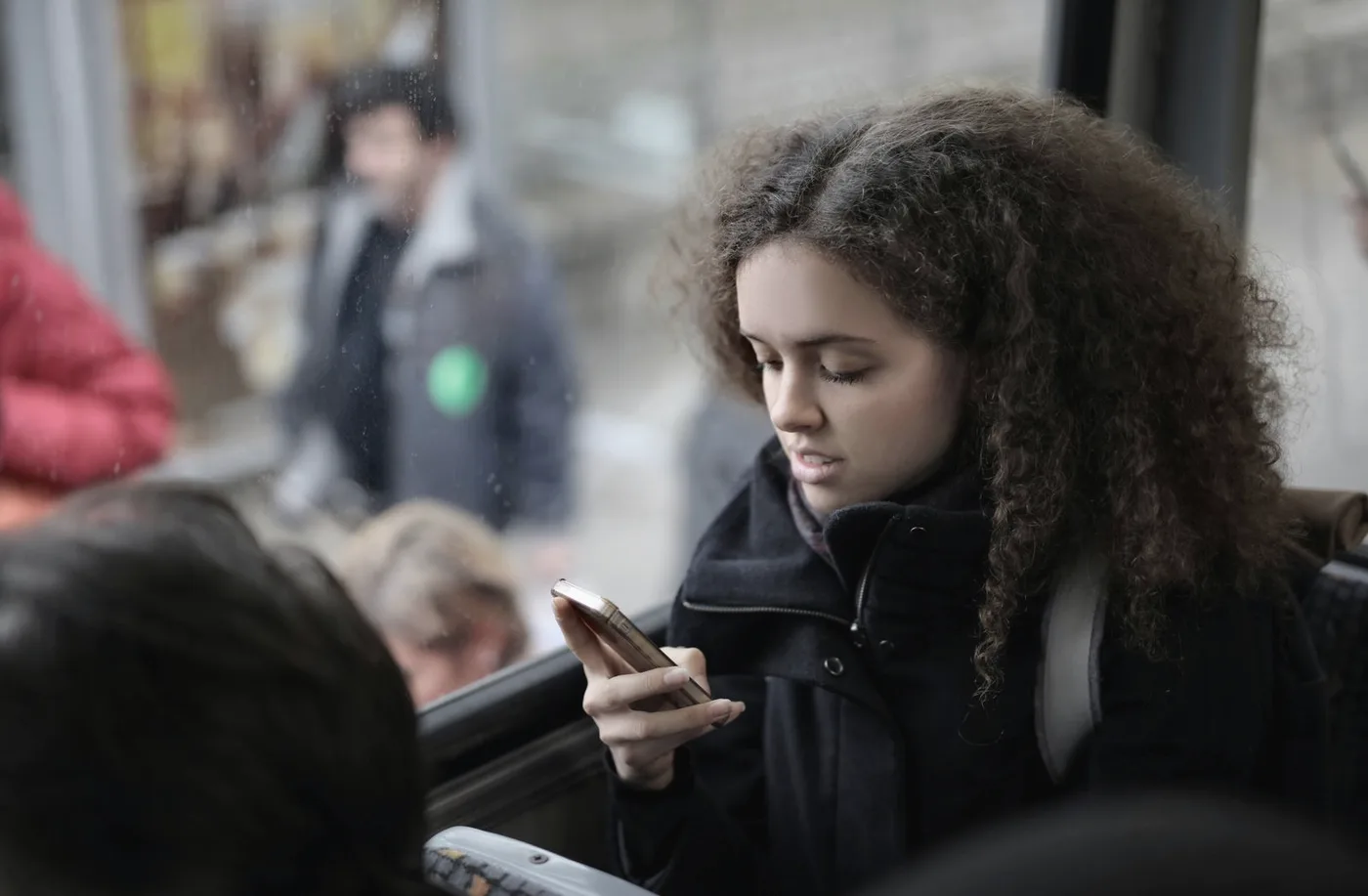 Moça lendo notícia no celular dentro do ônibus