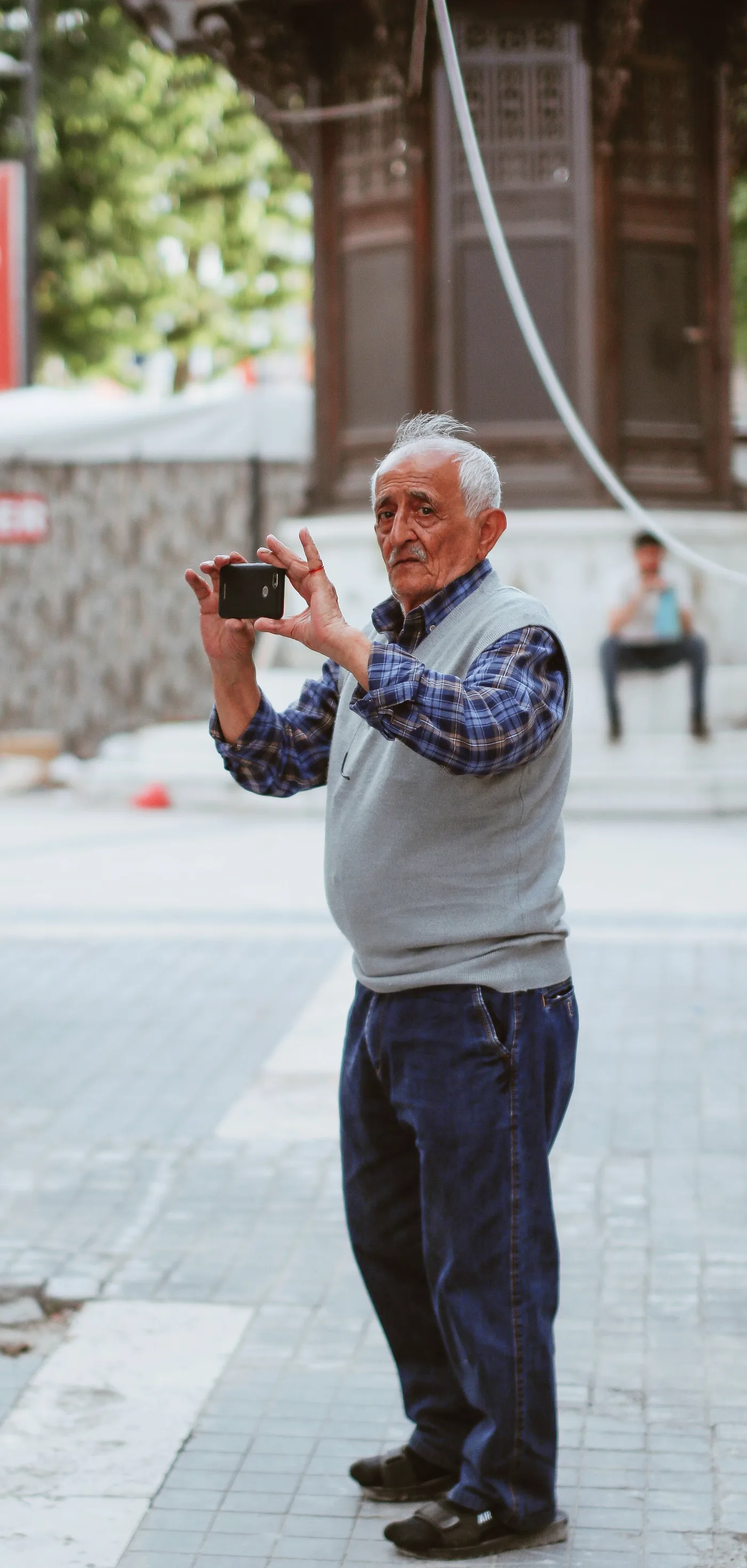 Senhor fotografando a rua com o celular