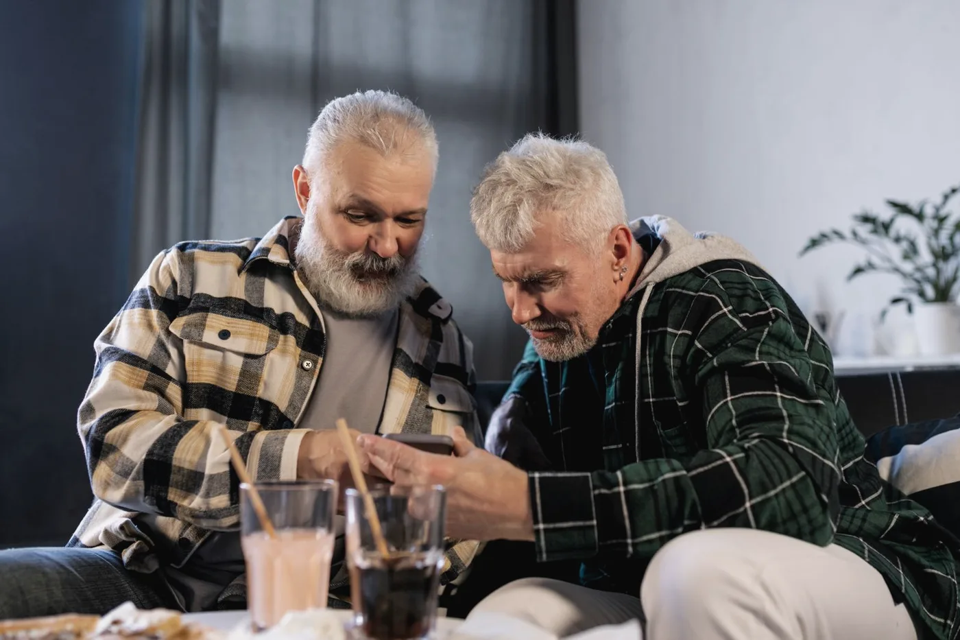 Dois senhores olhando juntos a tela de um celular