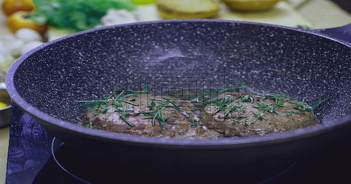Refeição de frutos do mar sendo preparada em uma única frigideira no fogão.
