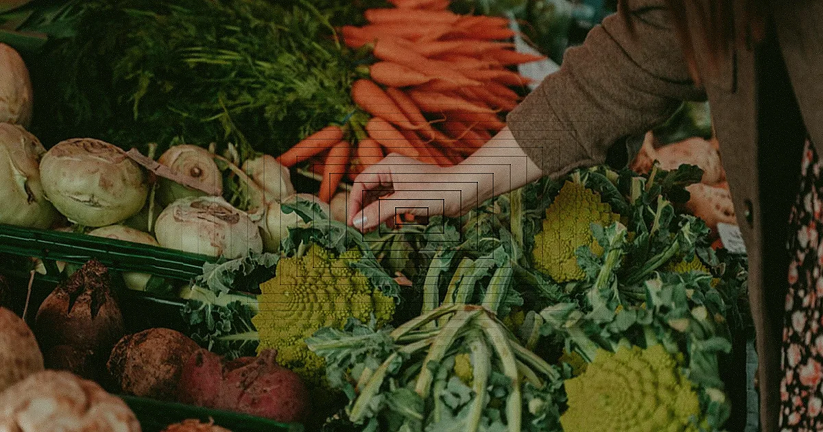 Bancada de mercado com uma variedade colorida de frutas e vegetais frescos e sazonais