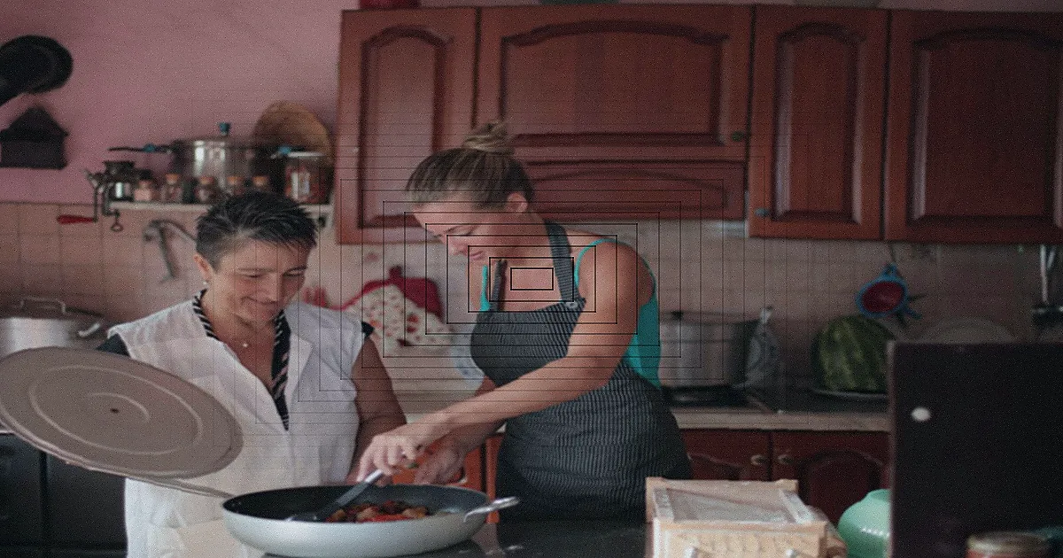 Família cozinhando junta na cozinha, com pais e filhos interagindo.